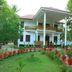 Achayans Homestay Mararikulam in Alappuzha, two-story white homestay with garden and potted plants