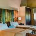 Posada Puerto Bemberg in Puerto Libertad: twin beds with rustic wood headboard beside a window and wardrobe