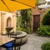 Hotel La Villa Serena in Antigua courtyard with yellow umbrella, fountain, and stone seating