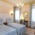 Cà Del Modena Venice room with two twin beds, chandelier, desk, and tall windows