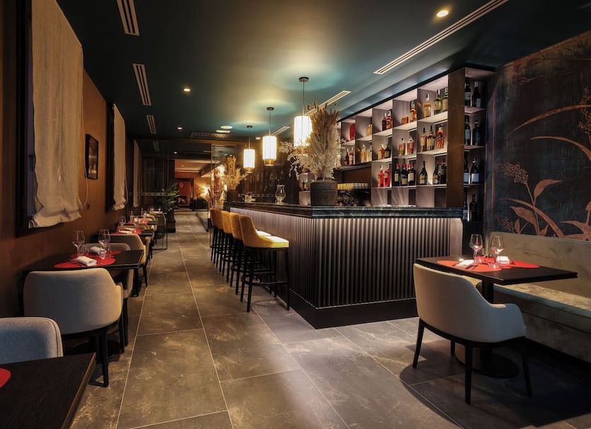 U-Visionary Venezia Hotel in Venice bar and lounge with high stools, tables, and backlit shelves