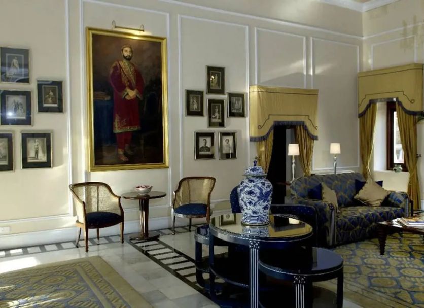 Ananda in the Himalayas in Rishikesh lounge with ornate decor, blue sofa, portrait, and large windows