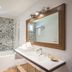 Oustau Camarguen Hôtel & Spa bathroom in Le Grau-du-Roi with bathtub, large mirror and patterned tile wall