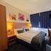 Elbbrücken Hotel Hamburg room with double bed, desk, lamp, and blue curtains