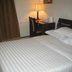 Jia Hao in Beijing guest room with bed, desk, chair, lamp, and curtains