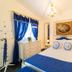 Casa Nostra Boutique Hotel in Paraty: elegant bedroom with blue accents, chandelier, and ornate mirror