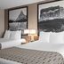 Super 8 by Wyndham Lewistown guest room with two beds, mountain wall art, and a chair