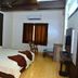 MM Tourist Home, Kāsaragod: guest room with double bed, wall-mounted TV, window and chair