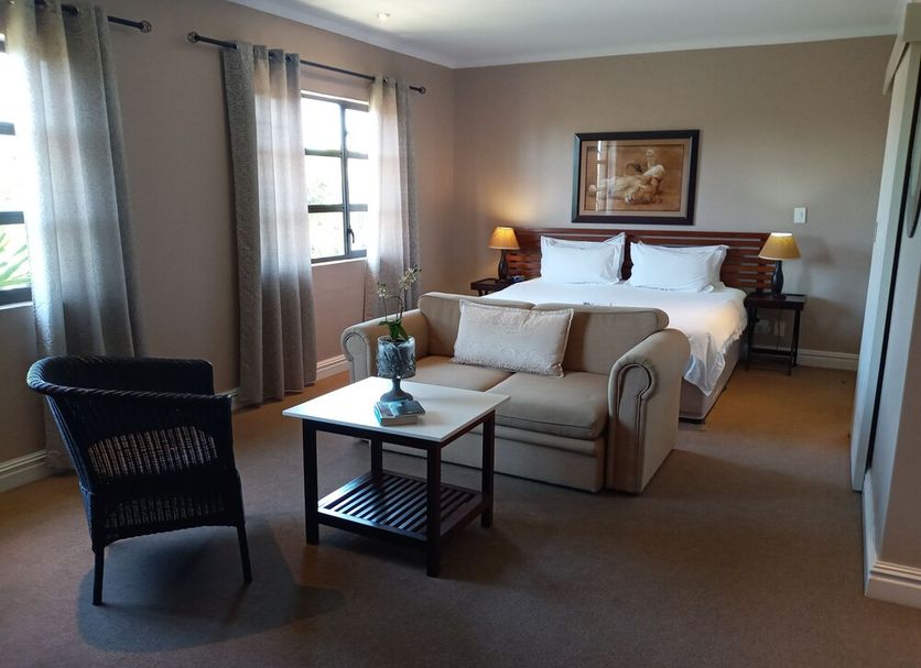 La Roche Guest House, Cape Town room with king bed, sofa, armchair, and side tables