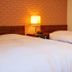 Fukuyama Terminal Hotel room in Fukuyama with two twin beds and a glowing bedside lamp