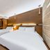 Friendly DH Naissance Hotel by Mindrum Group in Seoul guest room with two beds and wood-paneled wall