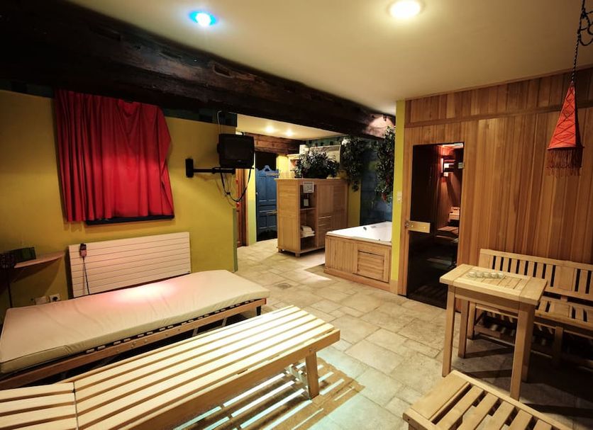 Salvators Bruges sauna room with wooden benches, tiled floor, and red curtains