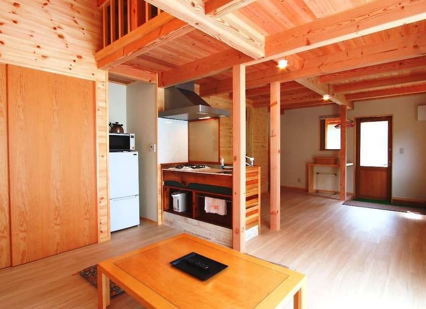 Tengu Onsen Asama Sanso in Komoro: rustic wooden guest room with kitchenette and loft sleeping area