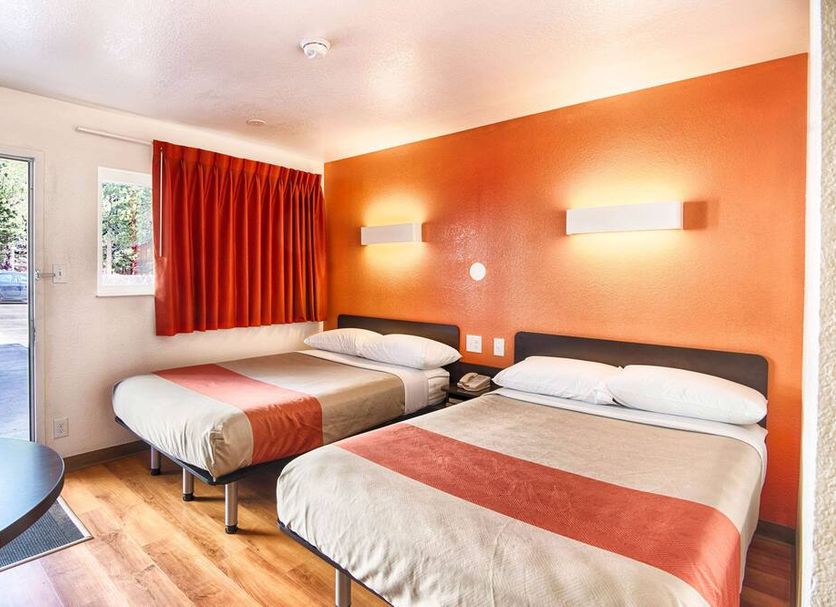 Motel 6 Mammoth Lakes guest room with two beds and orange accent wall
