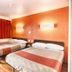 Motel 6 Mammoth Lakes guest room with two beds and orange accent wall