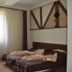 Magic Club Bușteni guest room with double bed, window, and wooden furniture