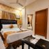 Housez 43 Kolkata guest room with double bed, floral wallpaper, wall AC and glass coffee table