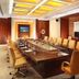 Power Valley International Hotel in Baoding boardroom with a long conference table, tan chairs, and recessed ceiling lights