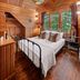 Hotel Mountain Brook, Tannersville: cozy wood-paneled bedroom with black metal bed, large windows, and pendant light.