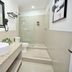 Rio Suites Tijuana bathroom with vessel sink, walk-in shower, toilet, and granite countertop