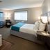 Paynesville Inn And Suites room with jetted tub, king bed, wall-mounted TV and window in Paynesville