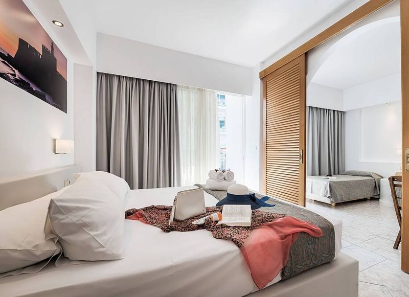 Esperia City Hotel Rhodes guest room with bed, mirrored wardrobe and view into second bedroom