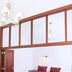 Bon Marie B&B in Hamilton: bed beneath loft-style wall openings and a chandelier in a simple guest room