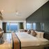 Sinclairs Bayview in Port Blair room with ocean view, desk, bed and large windows