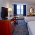 Federal City Inn & Suites New Orleans guest room with two beds, desk, TV, and window seating