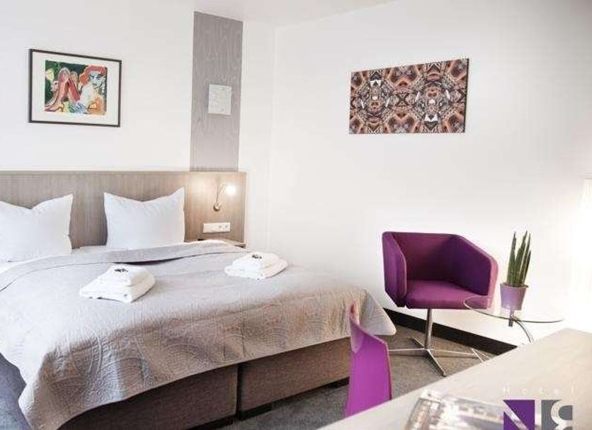 Hotel Nikolai Residence Berlin guest room with double bed, purple chair and wall art