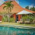 Three Monkeys Villas in South Kuta with a villa, pool, lounge chairs, and umbrellas