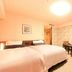 Richmond Hotel Naha Kumoji room in Naha with two twin beds, small table, and patterned accent wall