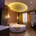 Kantar Hotel Yerevan room with round bed, warm lighting, desk, and window curtains