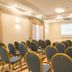 Hotel Premiere in Giugliano in Campania conference room with rows of blue chairs and projection screen
