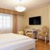 Allegro Hotel in Ljubljana guest room with king bed, desk, and wall-mounted TV