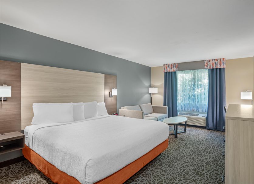 Best Western Porterville Inn guest room with king bed, armchair, and window view in Porterville