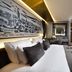 The Wings Hotels Karakoy in Istanbul guest room with king bed, city artwork, and floor-to-ceiling windows