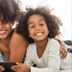 Western Motel Inn and Suites Hazlehurst family smiling on a bed while using a smartphone
