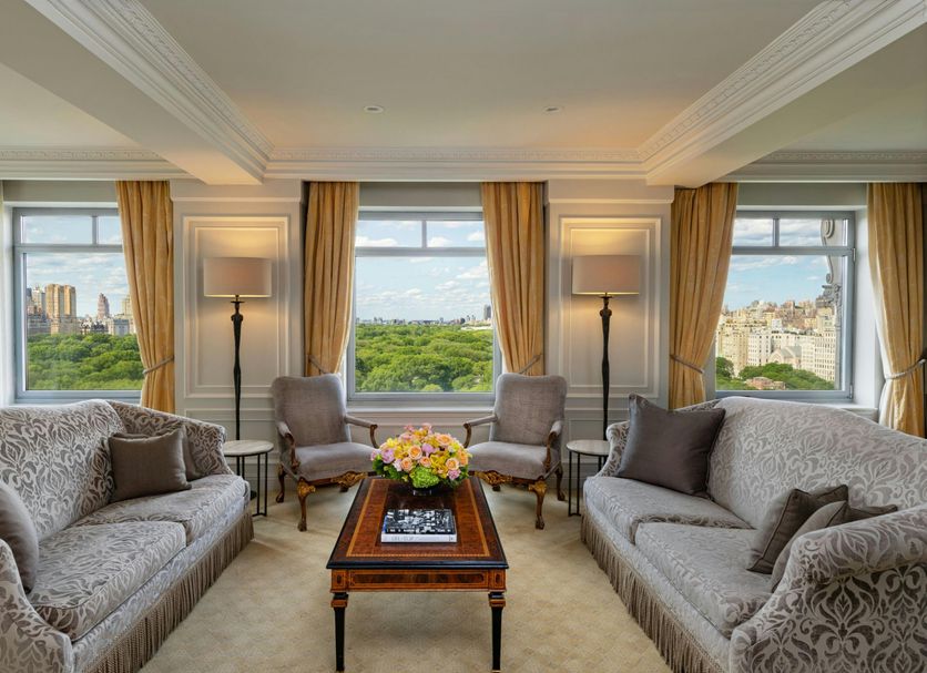 The Ritz-Carlton New York Central Park suite with park views, armchairs, and a coffee table