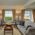 The Ritz-Carlton New York Central Park suite with park views, armchairs, and a coffee table