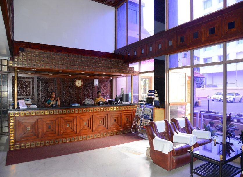 Hotel City Tower Coimbatore lobby with carved wood reception desk and seating area