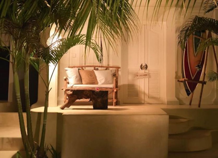 Sal Secret Spot in South Kuta: tropical patio with lounge chair, surfboard decor and palm trees