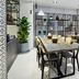Sercotel Madrid Aeropuerto dining area in Madrid with communal tables, chairs, and shelves