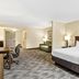 Country Inn & Suites by Radisson Princeton, WV guest room with king bed, desk, seating area and lamps