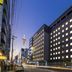 Dormy Inn Premium Kyoto Ekimae Natural Hot Spring exterior at dusk in Kyoto, with illuminated windows