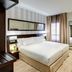 Sercotel Madrid Aeropuerto room in Madrid with king bed, desk, TV and mirror