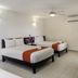 Hotel Maya Turquesa room in Playa del Carmen with two beds, ceiling fan, and wall-mounted air conditioner.