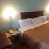 Rodeway Inn Jonesboro - Atlanta South room with queen bed, bedside lamps, and hardwood floor