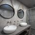 Hotel Sunshine in Kamari bathroom with double vessel sinks, round mirrors, and glass shower