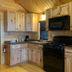 The Beach House in Mackinaw City: rustic wood kitchen with black appliances and cabinets